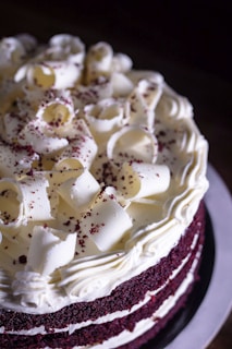 Decadent red velvet cake with cream cheese frosting and sprinkles.