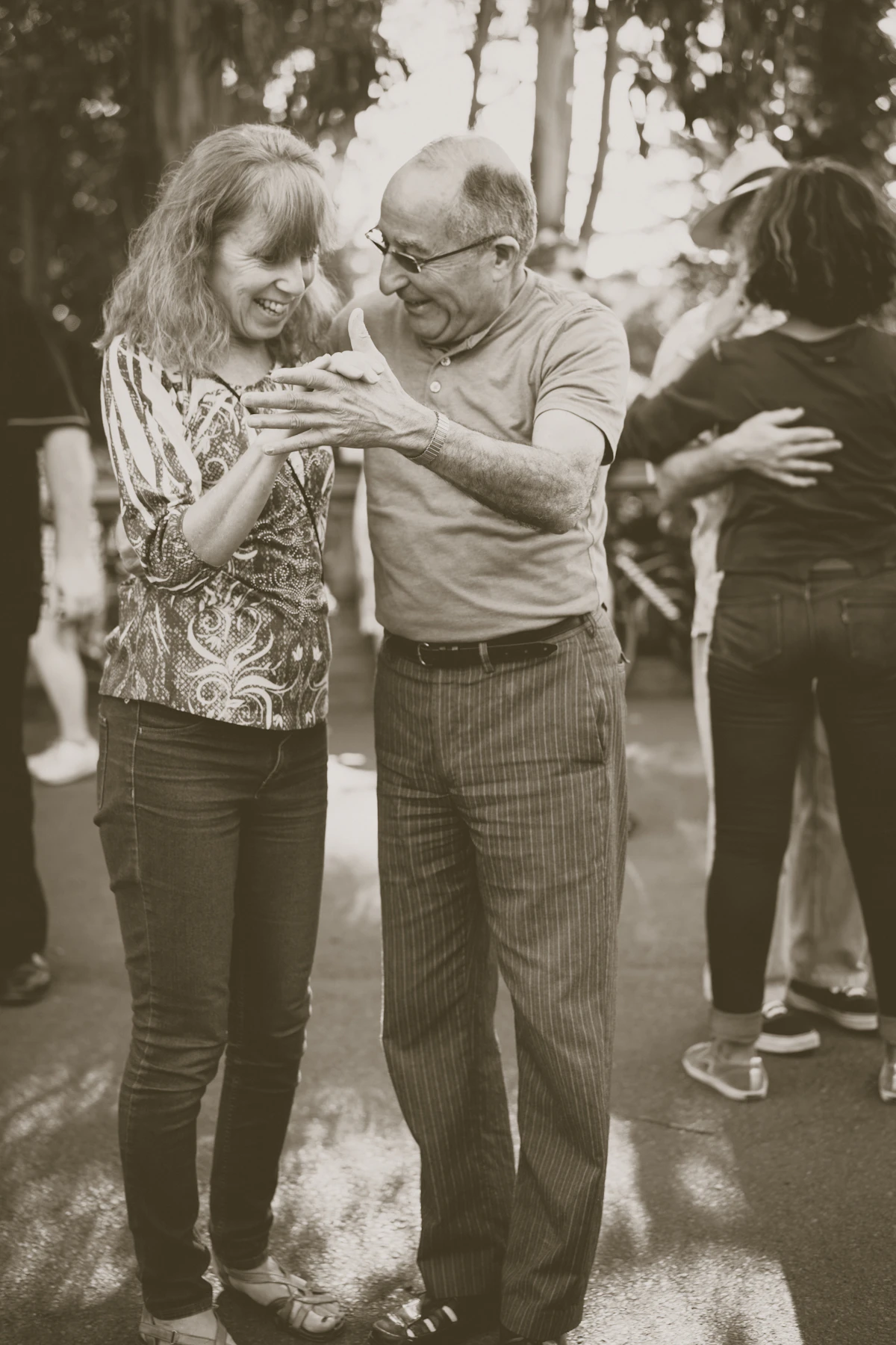 Dos personas bailan juntas al aire libre en una fotografía monocromática.