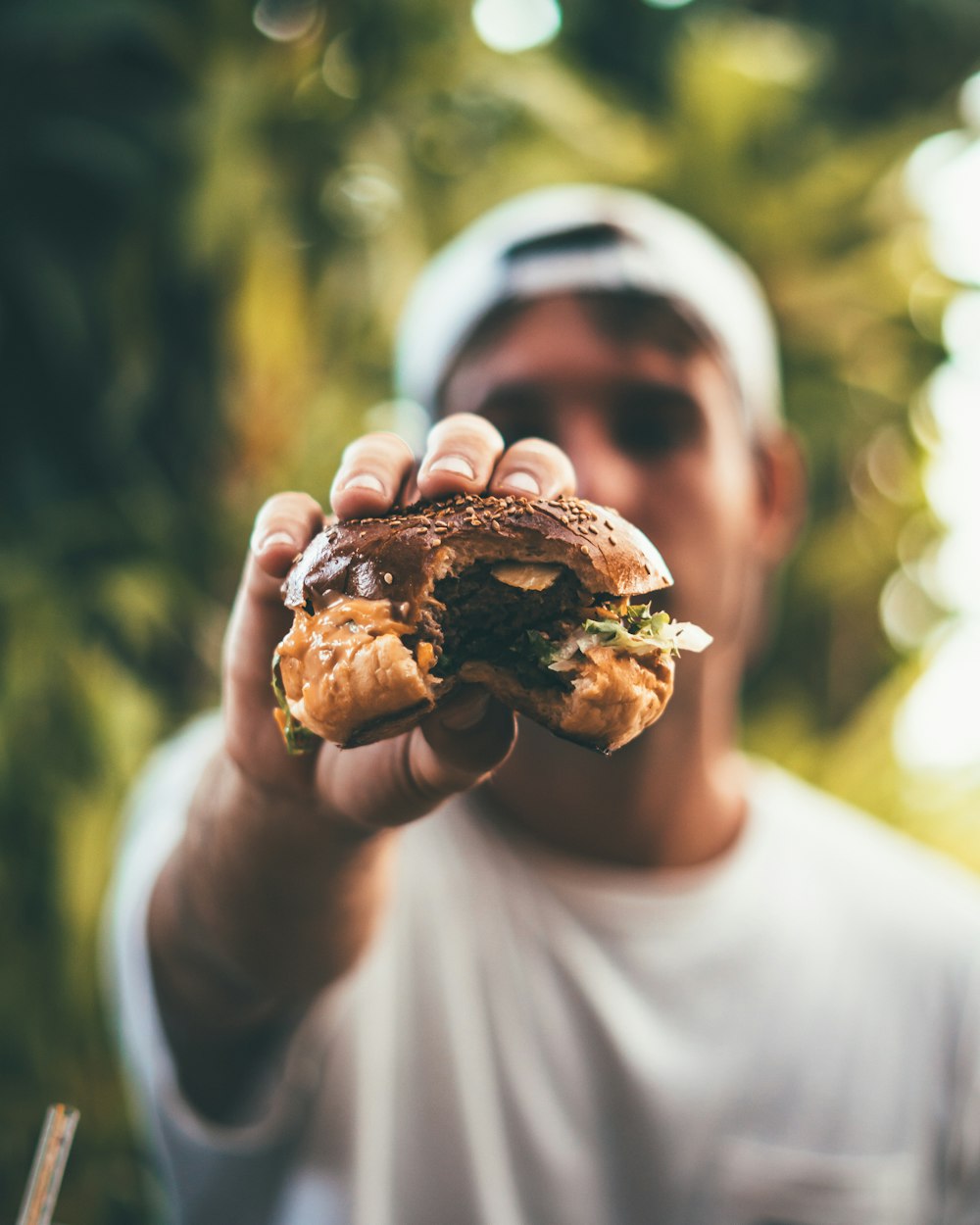 食べたハンバーガーを手にした男性のセレクティブフォーカス写真