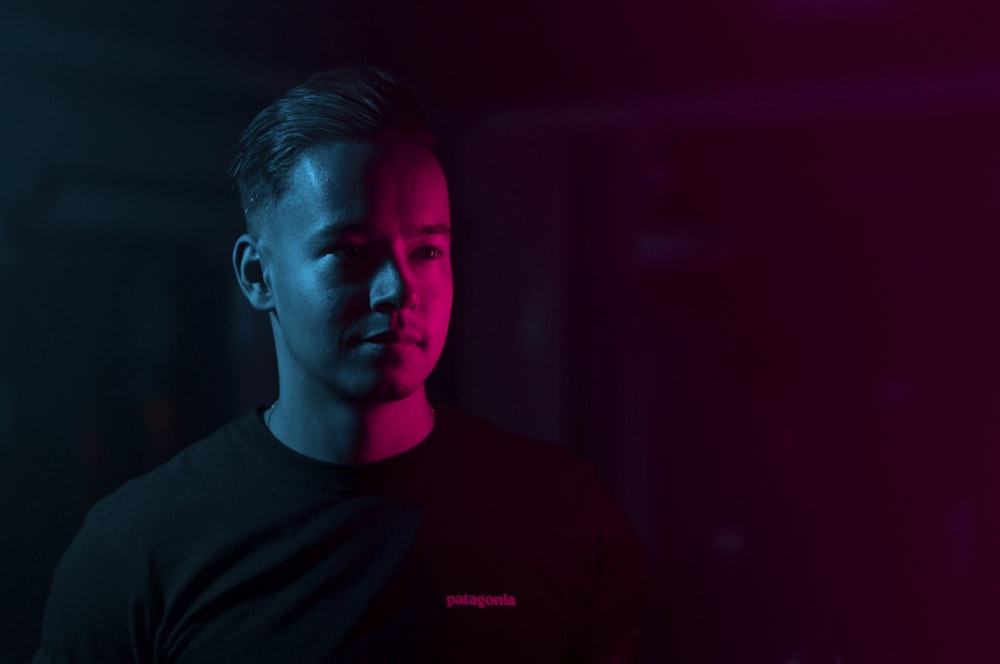 man standing inside room with neon lights