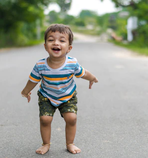 A joyful child wearing colorful Trivo shorts playing in a sunlit Cairo street.