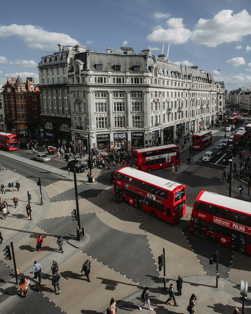 people walking on street near red double-deck buses