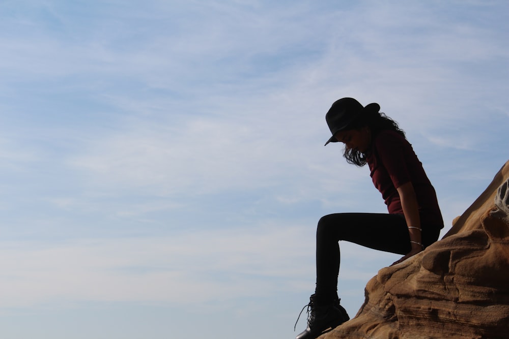 silhouette of man sitting on rock