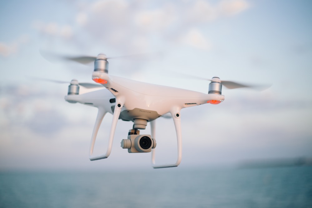 Photographie en gros plan d’un drone survolant un plan d’eau pendant la journée