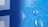 A close-up of a pixelated design with a blue color scheme and water droplets overlaid. The pattern consists of various shades of blue dots forming a gradient from light to dark. The droplets add a realistic, three-dimensional texture to the otherwise flat image.