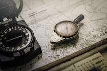 black and gray compass on top of map