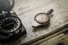 black and gray compass on top of map