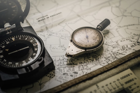 black and gray compass on top of map