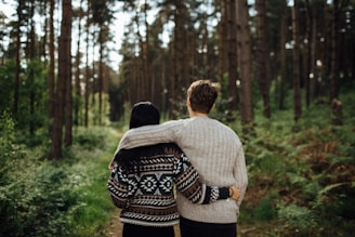 man's left arm over woman's shoulder
