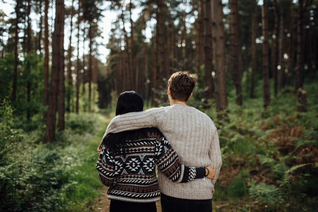 couple in sweaters on a forest walk