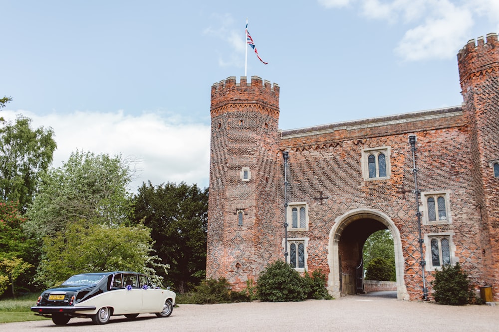 white and black car parked near stone castle