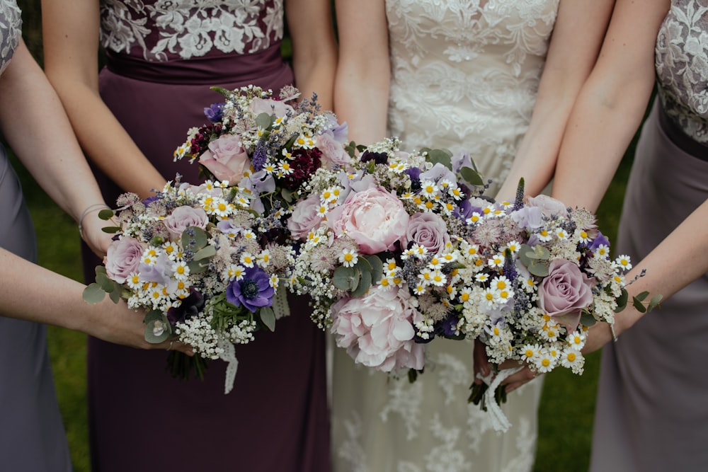 Cuatro mujeres que llevan un ramo de flores