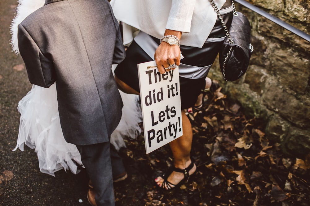 woman standing with boy while holding white signage