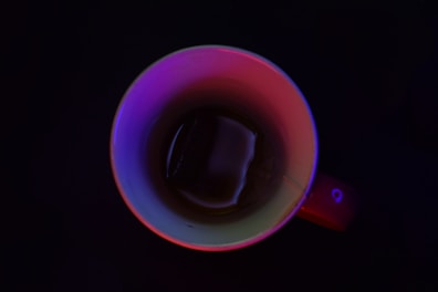 A futuristic LED cup illuminating soft purple light in a modern kitchen setting.