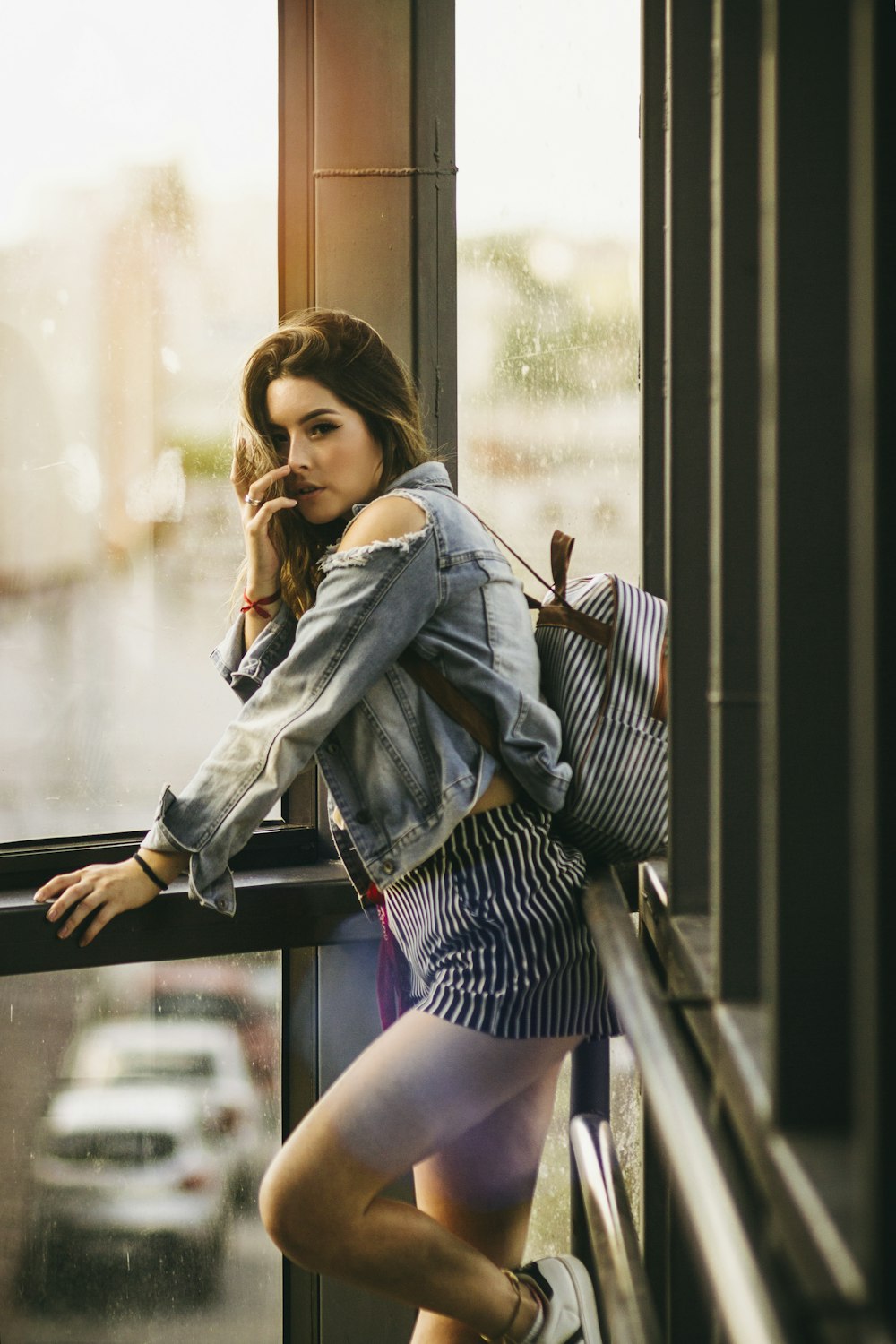 woman standing beside glass window