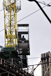 man sitting on crane tower