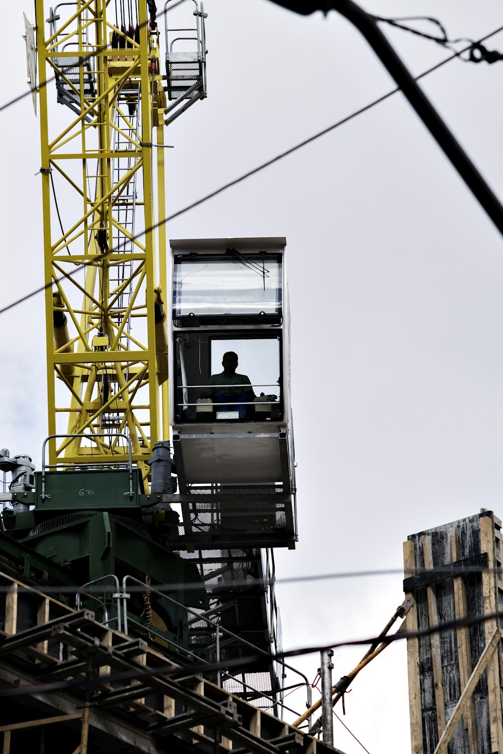 man sitting on crane tower