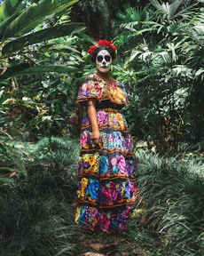 standing woman surrounded by green plants and trees during daytime