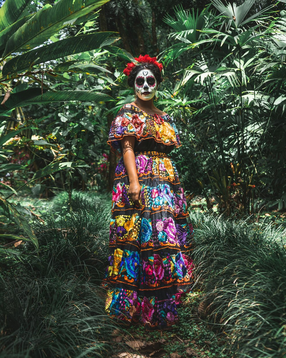 standing woman surrounded by green plants and trees during daytime