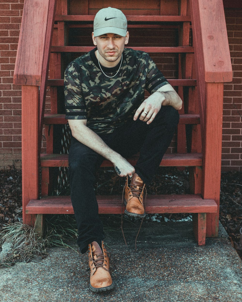 homem sentado em escadas de madeira marrom
