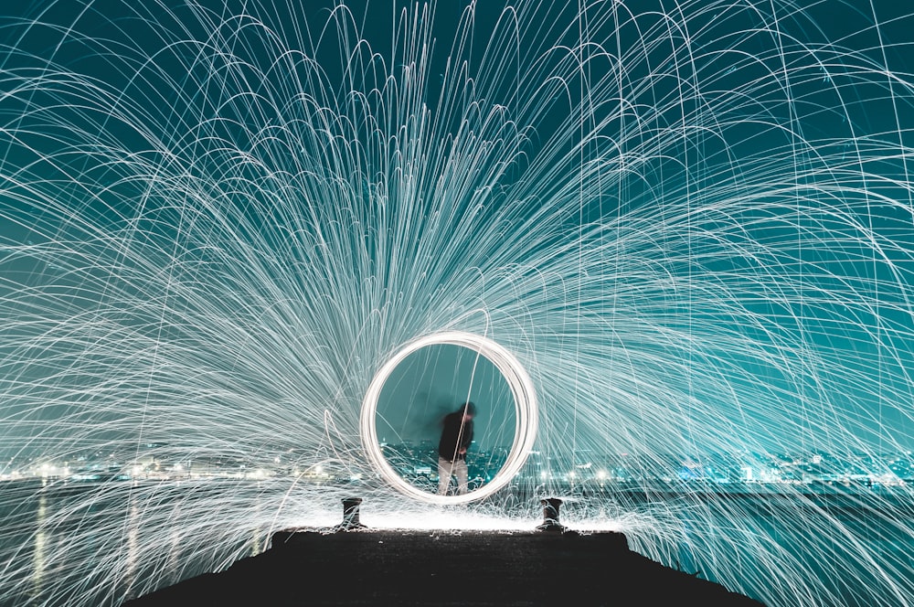 man standing on dock steel wool photography