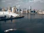 city across body of water under white clouds