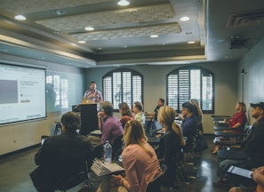 a group of people in a room with a projector screen