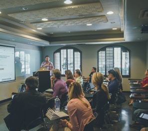 a group of people in a room with a projector screen