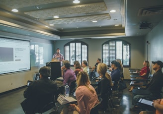 a group of people in a room with a projector screen