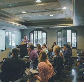 a group of people in a room with a projector screen