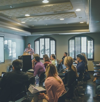 a group of people in a room with a projector screen