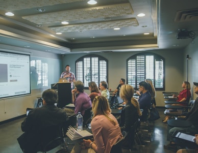 a group of people in a room with a projector screen