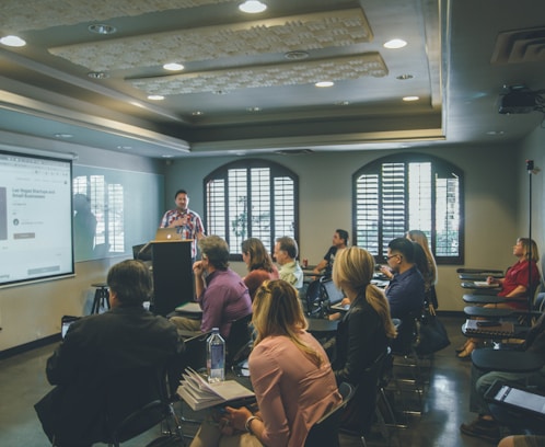 a group of people in a room with a projector screen