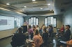 a group of people in a room with a projector screen