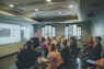 a group of people in a room with a projector screen