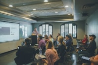 a group of people in a room with a projector screen