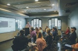 a group of people in a room with a projector screen