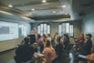 a group of people in a room with a projector screen