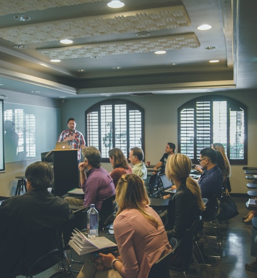 a group of people in a room with a projector screen