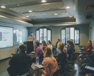 a group of people in a room with a projector screen