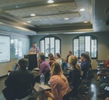 a group of people in a room with a projector screen