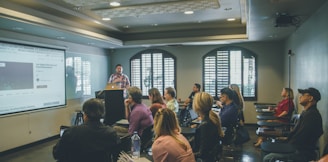 a group of people in a room with a projector screen