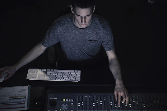 David Conroy working at a mixing console in a broadcast studio, focused and engaged.