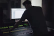 Close-up of a sound engineer mixing audio on a professional console in a dimly lit studio.