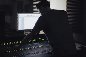 Sound engineer mixing audio tracks in a professional studio environment.
