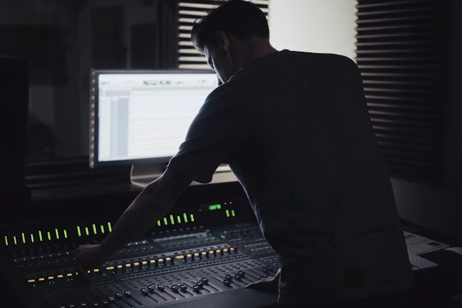 Sound engineer working with audio mixing console in studio