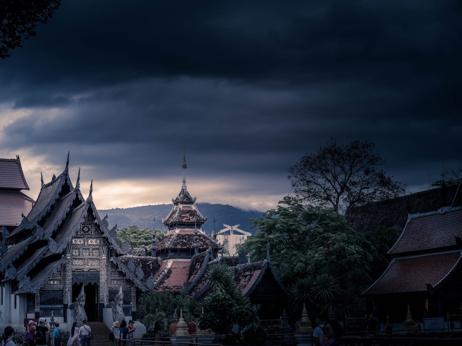 Traditional Thai temple silhouetted against a moody dawn sky in Chiang Mai