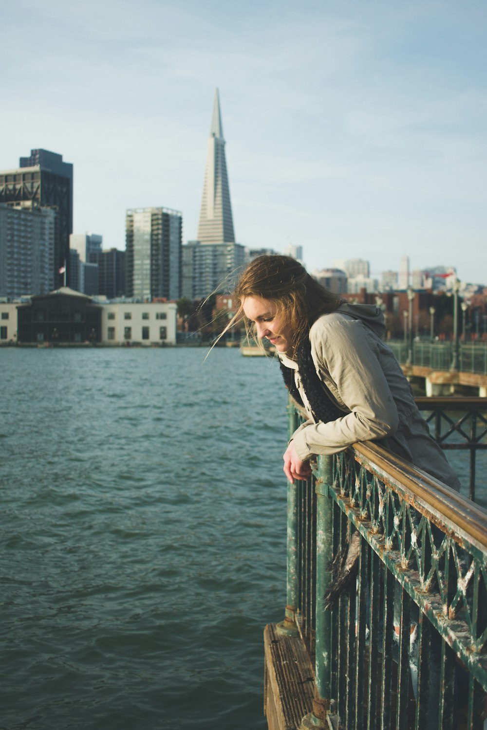 woman leaning on green steel fence