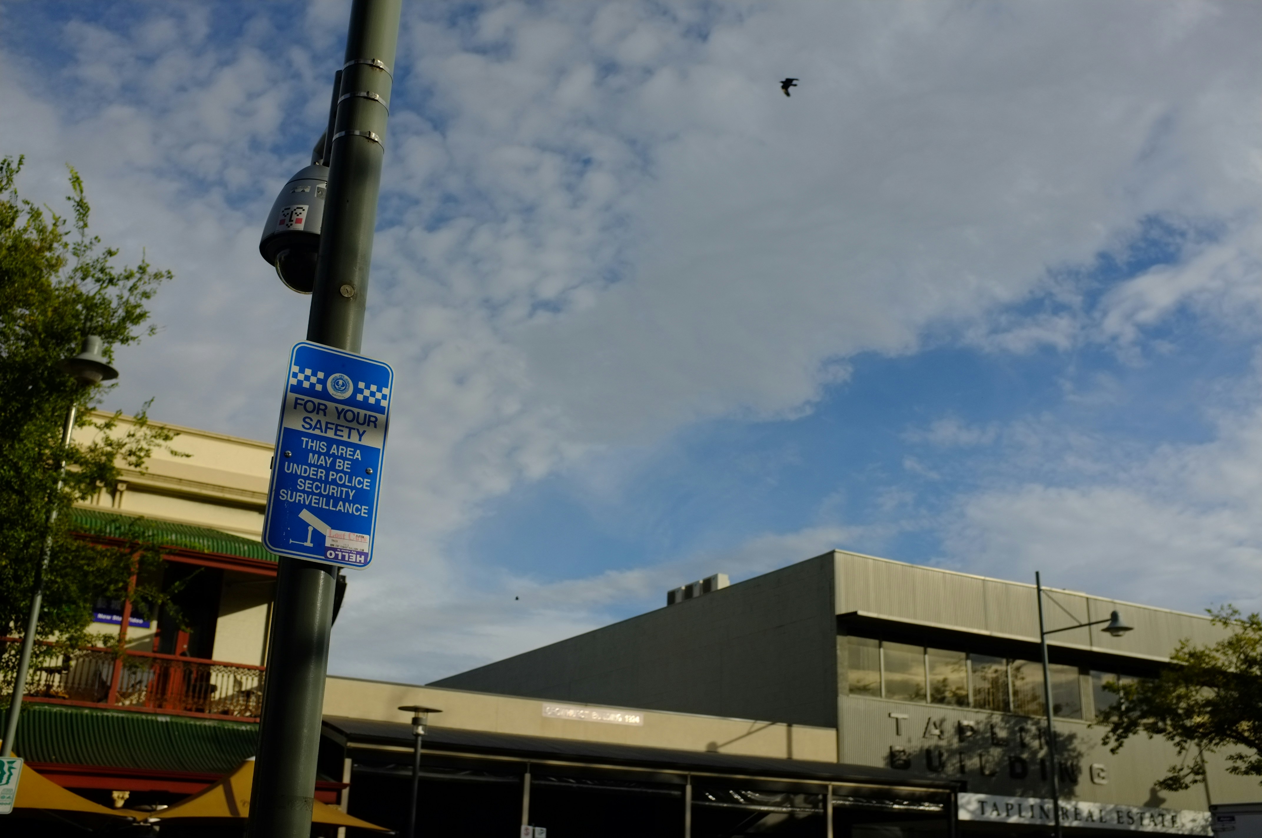 Security camera mounted on pole in parking area at night with bright street lighting, surveillance system in outdoor environment