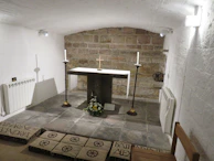 A small group in prayer inside a minimalistic chapel